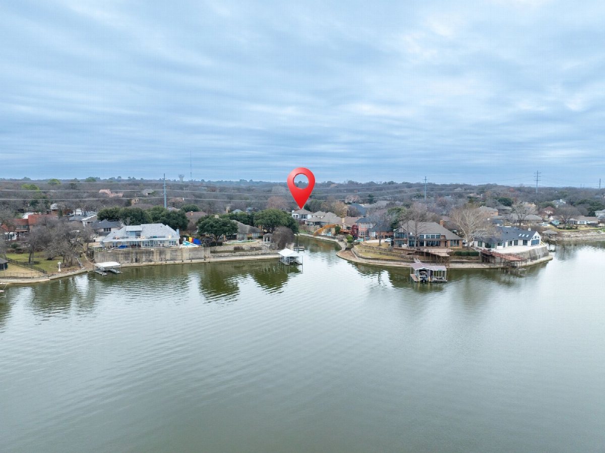 Aerial view of a lakeside neighbourhood with a location pin marking a property.