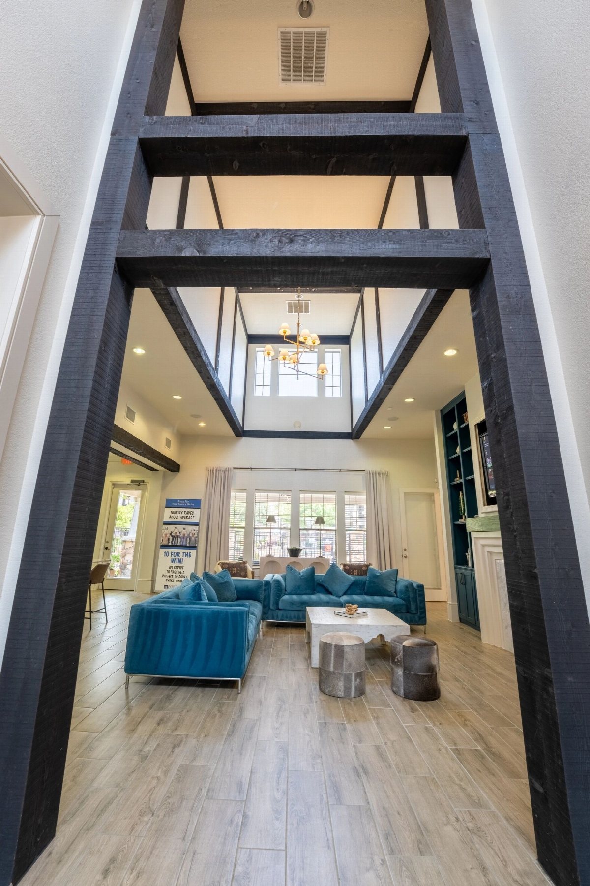 Entry hall framed by dark timber beams looking through to a seating area.